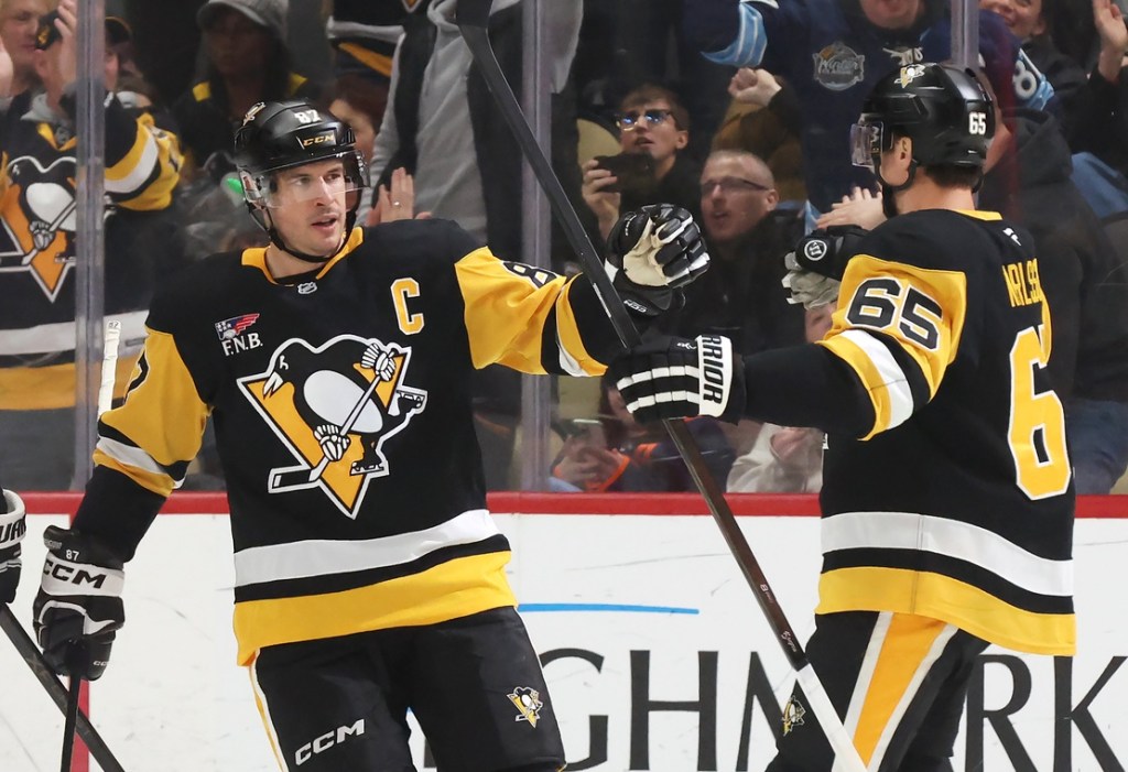 Dec 16, 2025; Pittsburgh, Pennsylvania, USA; Pittsburgh Penguins center Sidney Crosby (87) congratulates defenseman Erik Karlsson (65) on his goal against the Edmonton Oilers during the second period at PPG Paints Arena.