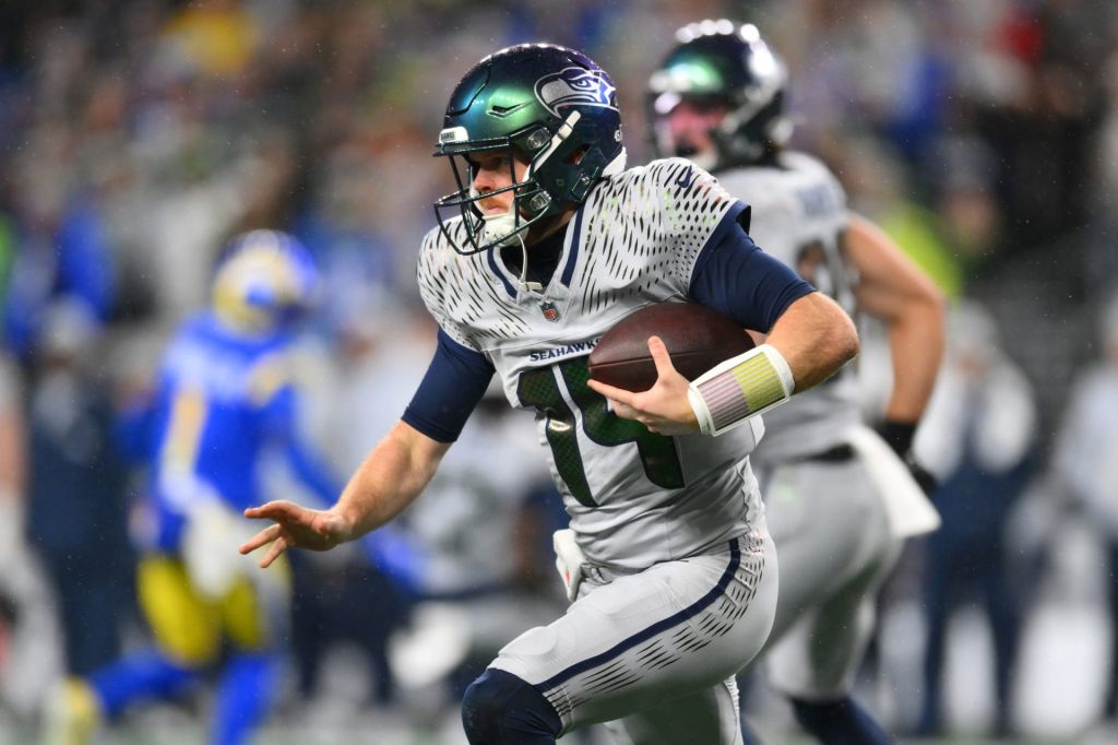 Dec 18, 2025; Seattle, Washington, USA; Seattle Seahawks quarterback Sam Darnold (14) runs against the Los Angeles Rams in the first half at Lumen Field.