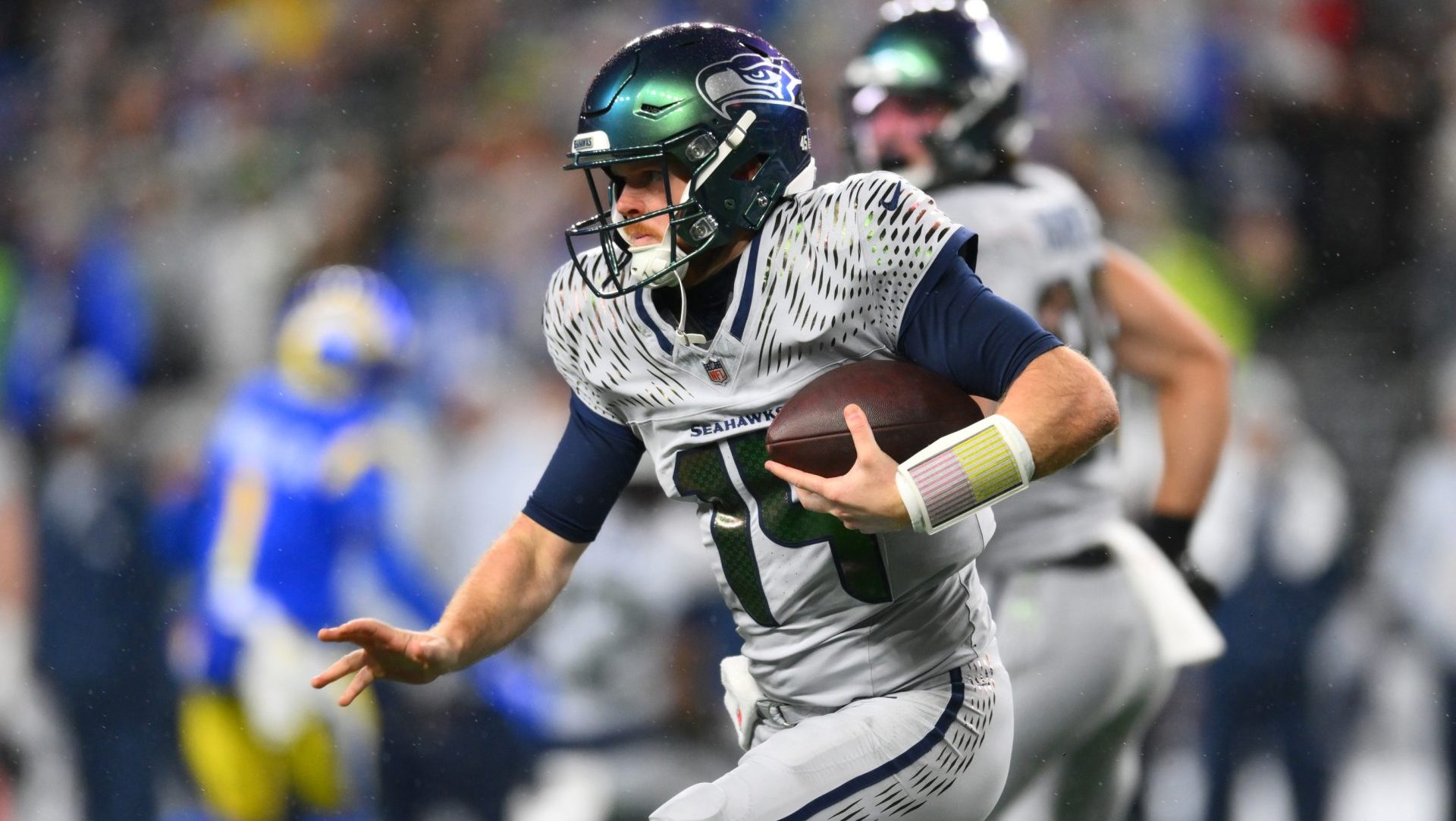 Dec 18, 2025; Seattle, Washington, USA; Seattle Seahawks quarterback Sam Darnold (14) runs against the Los Angeles Rams in the first half at Lumen Field.