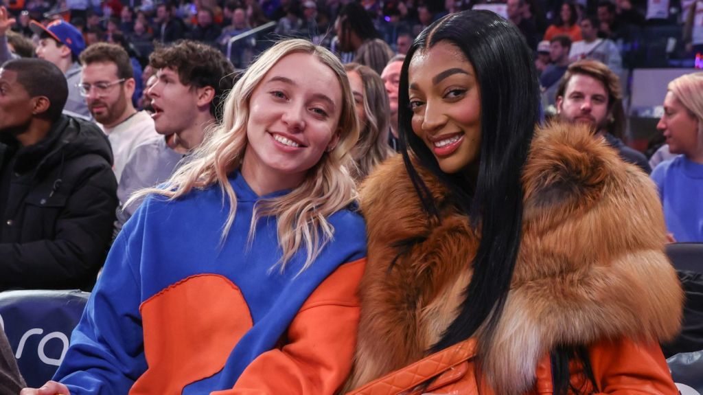 Dec 7, 2025; New York, New York, USA; WNBA players Paige Bueckers (l) and Angel Reese (r) sit courtside during the game between the Orlando Magic and the New York Knicks at Madison Square Garden.