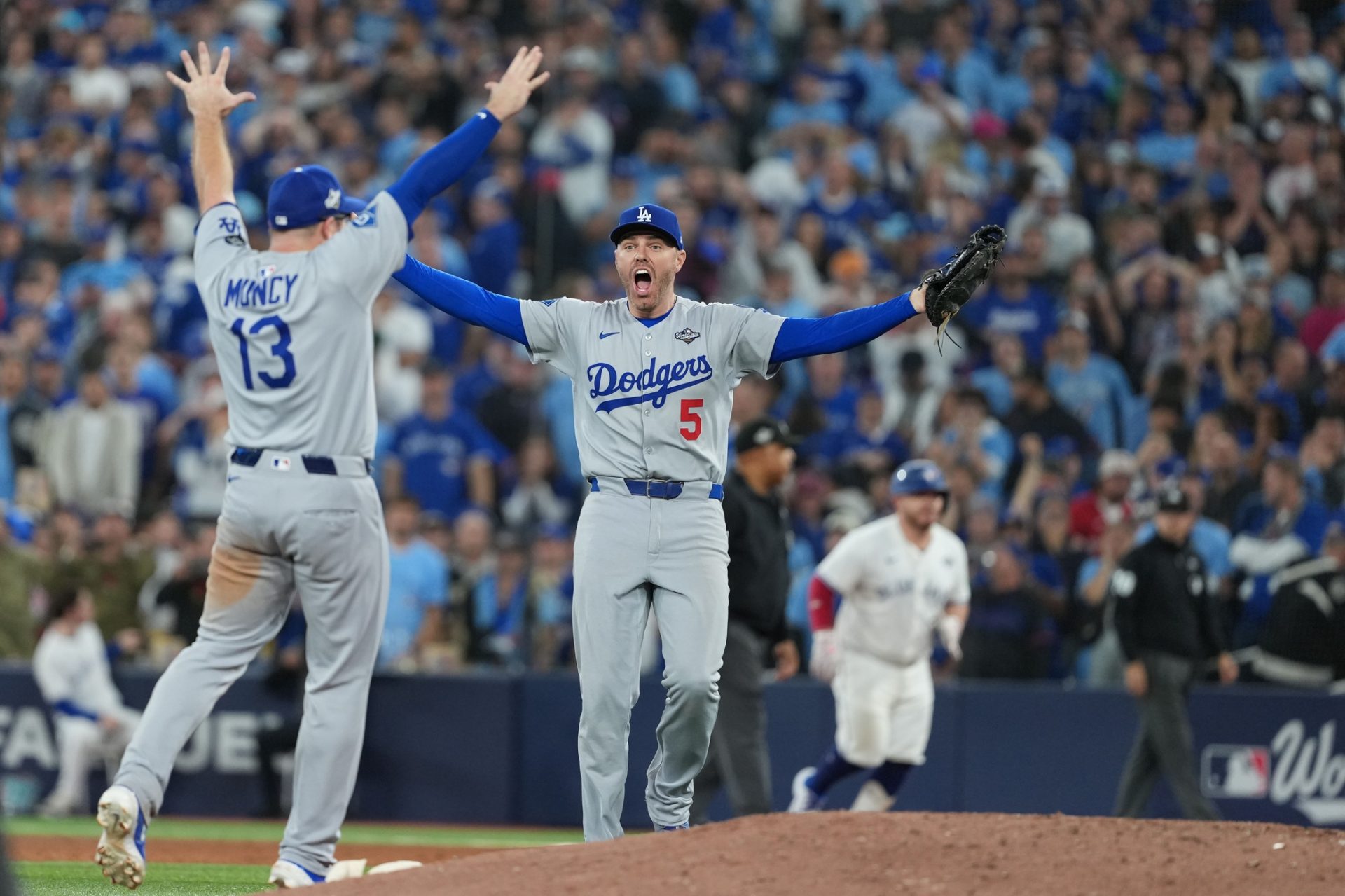 Nov 1, 2025; Toronto, Ontario, CAN; Los Angeles Dodgers first baseman Freddie Freeman (5) reacts with third baseman Max Muncy (13) after defeating the Toronto Blue Jays in the eleventh inning for game seven of the 2025 MLB World Series at Rogers Centre.