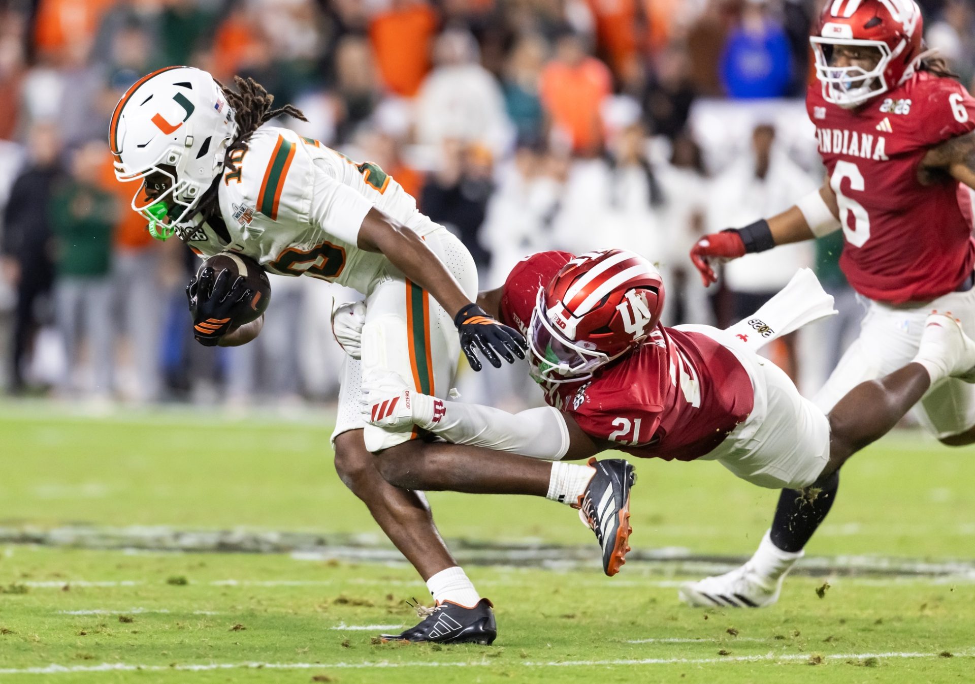 Jan 19, 2026; Miami Gardens, FL, USA; Miami Hurricanes wide receiver Malachi Toney (10) is tackled by Indiana Hoosiers linebacker Rolijah Hardy (21) during the College Football Playoff National Championship game at Hard Rock Stadium.
