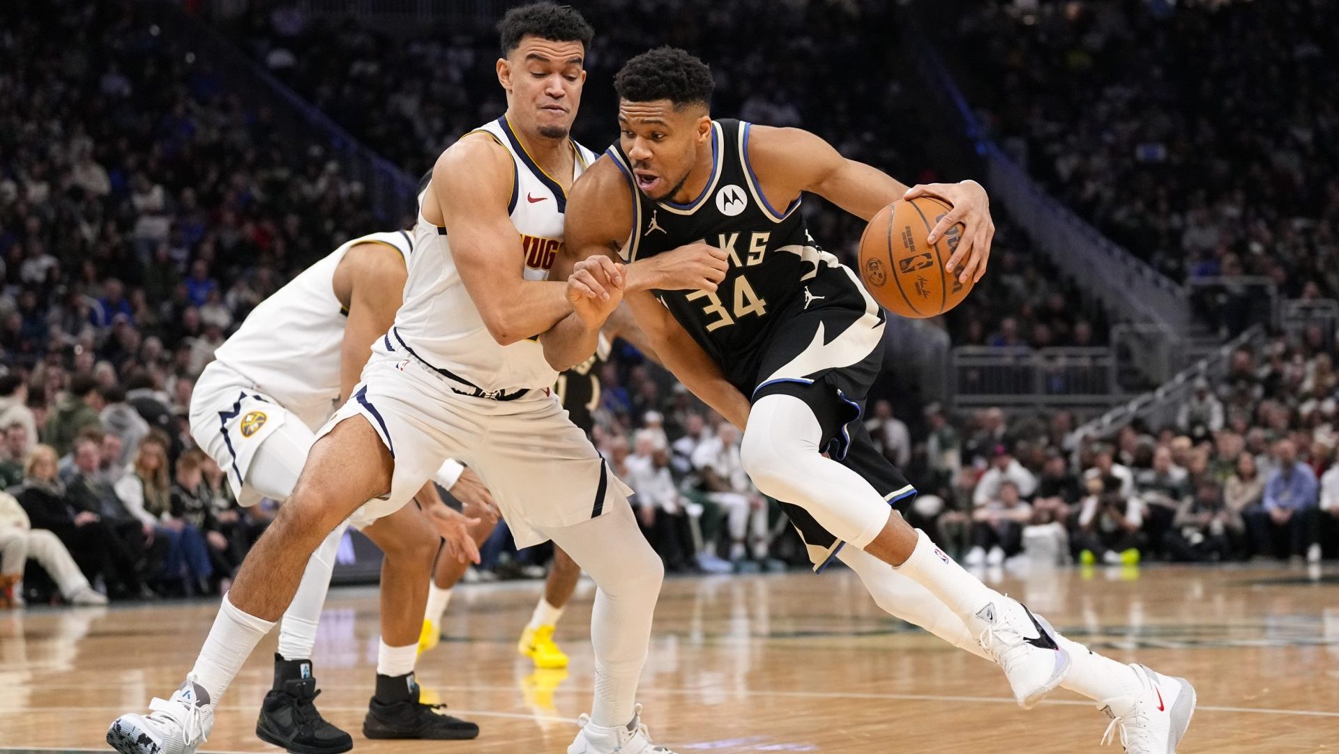 Jan 23, 2026; Milwaukee, Wisconsin, USA; Milwaukee Bucks forward Giannis Antetokounmpo (34) drives for the basket against Denver Nuggets forward Spencer Jones (21) during the second quarter at Fiserv Forum.