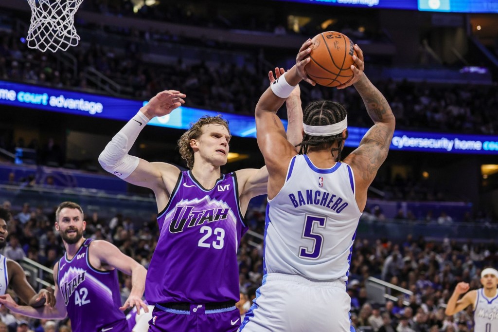 Feb 7, 2026; Orlando, Florida, USA; Utah Jazz forward Lauri Markkanen (23) defends Orlando Magic forward Paolo Banchero (5) during the second quarter at Kia Center.