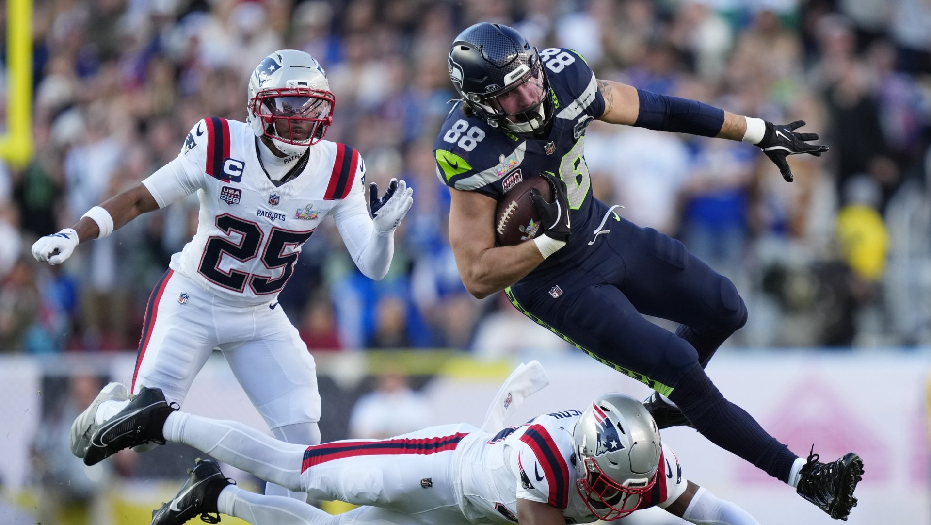 Feb 8, 2026; Santa Clara, CA, USA; Seattle Seahawks tight end AJ Barner (88) makes a catch against New England Patriots safety Craig Woodson (31) and cornerback Marcus Jones (25) during the first quarter in Super Bowl LX at Levi's Stadium.