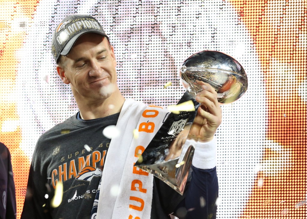 Feb 7, 2016; Santa Clara, CA, USA; Denver Broncos quarterback Peyton Manning (18) looks at the Vince Lombardi Trophy after beating the Carolina Panthers in Super Bowl 50 at Levi's Stadium