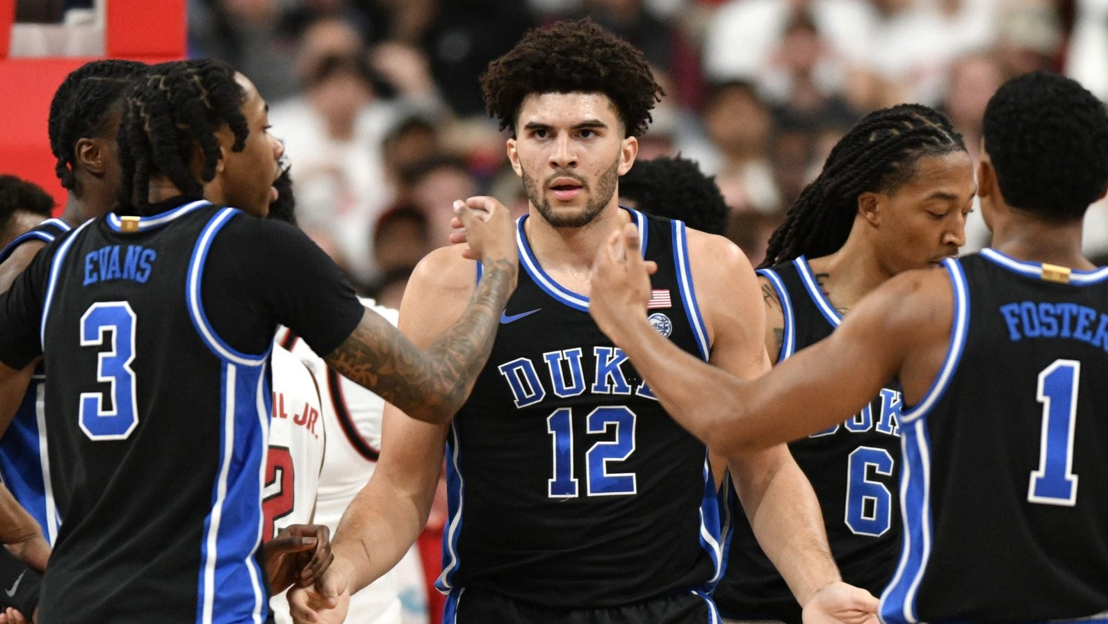 Mar 2, 2026; Raleigh, North Carolina, USA; Duke Blue Devils forward Cameron Boozer (12) reacts with guard Isaiah Evans (3) and guard Caleb Foster (1) after being fouled during the first half against the NC State Wolfpack at Lenovo Center.