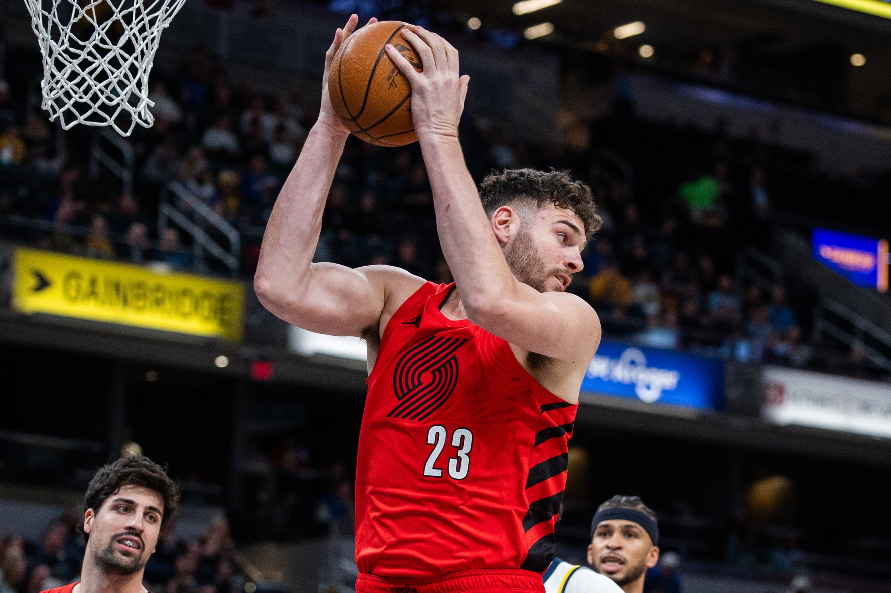 Mar 18, 2026; Indianapolis, Indiana, USA; Portland Trail Blazers center Donovan Clingan (23) rebounds the ball as Indiana Pacers forward Jalen Slawson (18) defends in the first half at Gainbridge Fieldhouse.