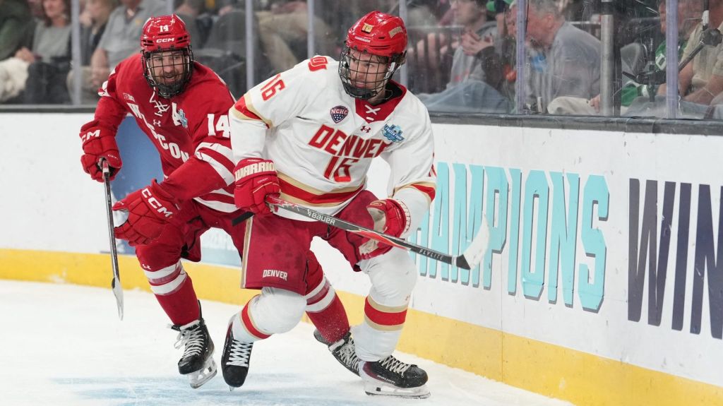 Apr 11, 2026; Las Vegas, Nevada, United States; Wisconsin Badgers defenseman Joe Palodichuk (14) and Denver Pioneers forward Kyle Chyzowski (16) battle for control of the puck during the second period in the championship game of the NCAA men's ice hockey Frozen Four at T-Mobile Arena
