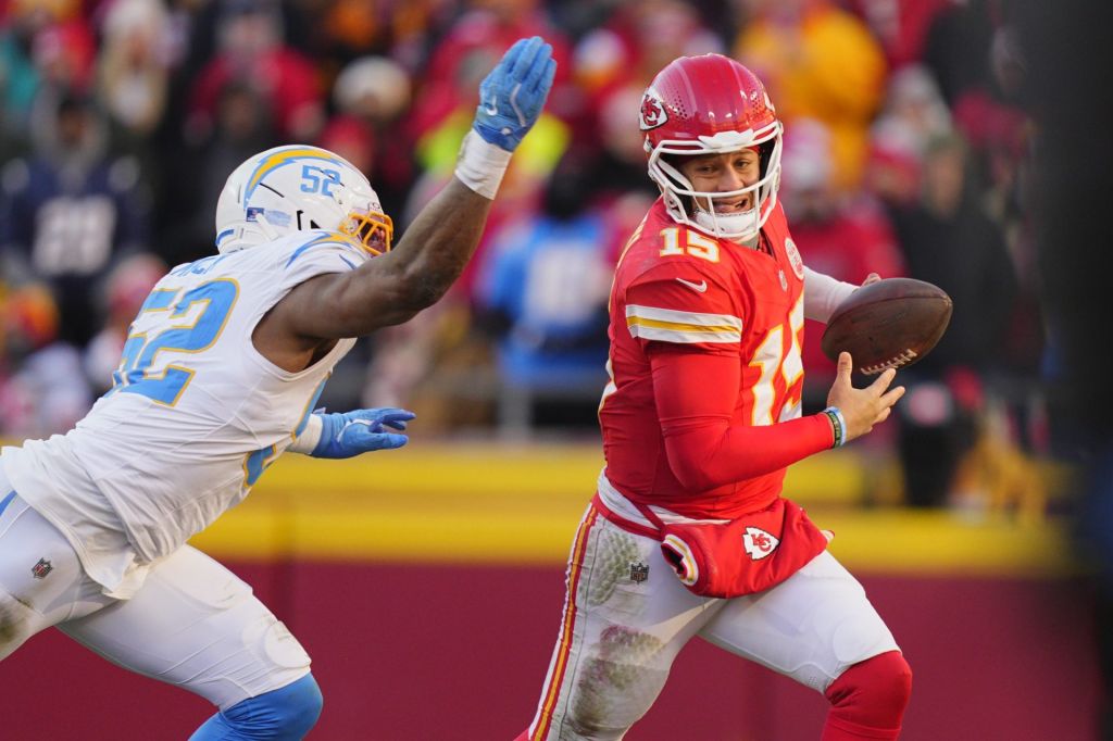Dec 14, 2025; Kansas City, Missouri, USA; Kansas City Chiefs quarterback Patrick Mahomes (15) scrambles against Los Angeles Chargers linebacker Khalil Mack (52) during the second half at GEHA Field at Arrowhead Stadium.