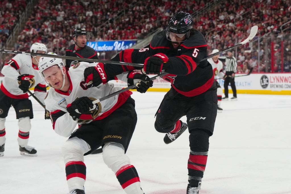 Apr 18, 2026; Raleigh, North Carolina, USA; Carolina Hurricanes defenseman Jalen Chatfield (5) checks Ottawa Senators left wing Brady Tkachuk (7) during the second period in game one of the first round of the 2026 Stanley Cup Playoffs at Lenovo Center.