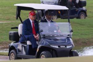 Apr 3, 2025; Miami, Florida, USA; President Donald Trump and his son, Eric Trump, drive in a golf cart after he arrived on Marine One at the LIV Golf Miami golf tournament at Trump National Doral.