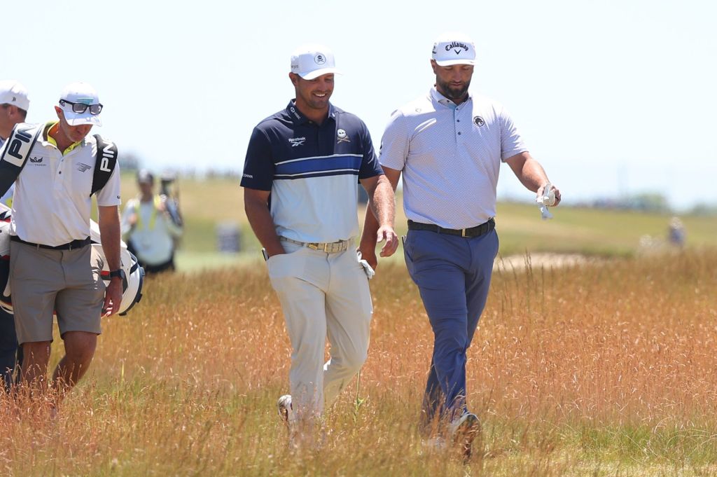 Jun 17, 2026; Southampton, New York, USA; Bryson DeChambeau (L) and Jon Rahm (R) walk together during a practice round for the U.S. Open golf tournament.