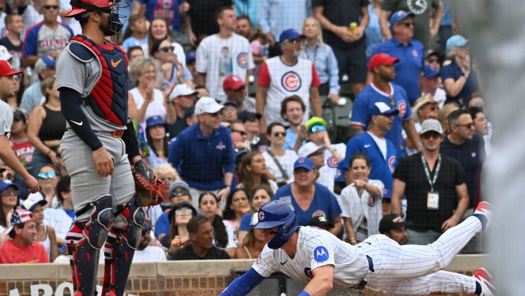 Jul 5, 2026; Chicago, Illinois, USA; Chicago Cubs second baseman Nico Hoerner (2) slides into score against the St. Louis Cardinals during the sixth inning at Wrigley Field.