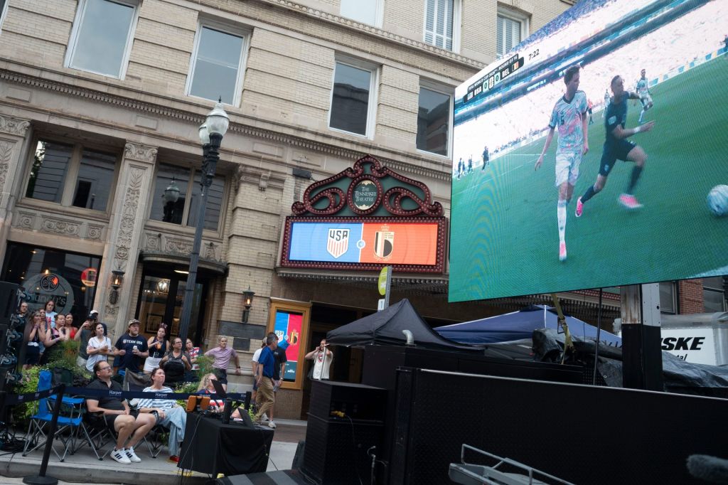 A giant screen broadcasts the U.S. and Belgium World Cup match during an outdoor watch party on Gay St. on July 6, 2026, in Knoxville, Tennessee.