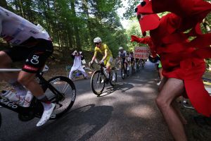 Cycling - Tour de France - Stage 9 - Malemort to Ussel - Malemort, France - July 12, 2026 UAE Team Emirates - XRG's Tadej Pogacar wearing the yellow jersey, UAE Team Emirates - XRG's Isaac Del Toro wearing the white jersey and Team Visma | Lease a Bike's Jonas Vingegaard wearing the polka-dot jersey in action as a spectator dressed in a costume cheers on during stage 9