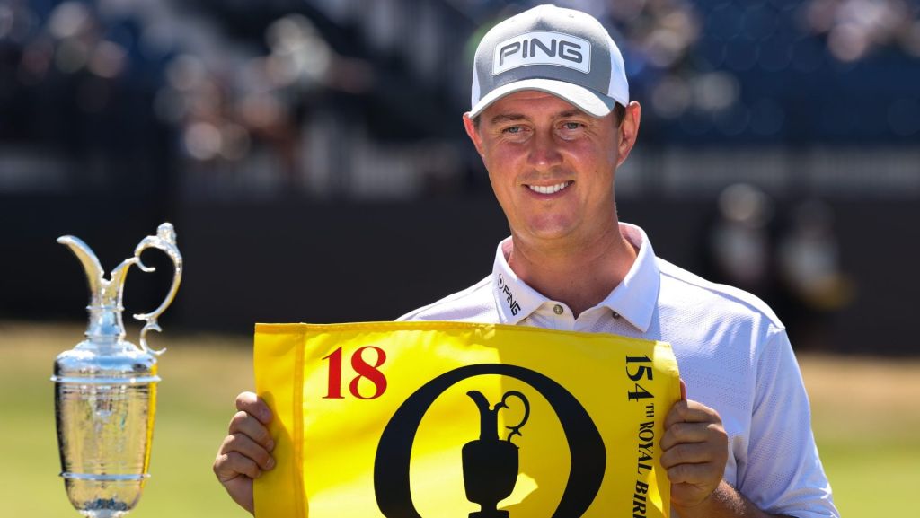 Jul 13, 2026; Southport, England; Joe Dean poses with an eighteenth hole flag alongside the Claret Jug as he wins the Last Qualifier for The Open Championship golf tournament at Royal Birkdale. Mandatory Credit: Bill Streicher-Imagn Images