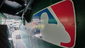 Aug 24, 2024; Oakland, California, USA; The major league baseball logo is seen on signage near the player's entrance to the field at Oakland-Alameda County Coliseum before the game between the Oakland Athletics and the Milwaukee Brewers. Mandatory Credit: Robert Edwards-USA TODAY Sports
