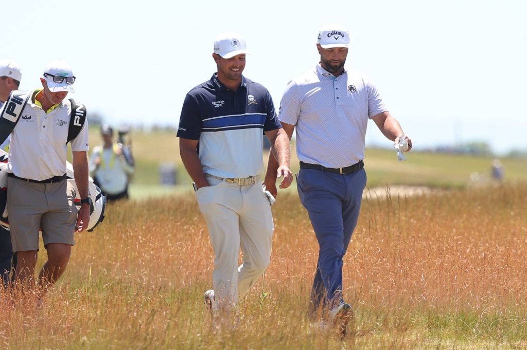Jun 17, 2026; Southampton, New York, USA; Bryson DeChambeau (L) and Jon Rahm (R) walk together during a practice round for the U.S. Open golf tournament.